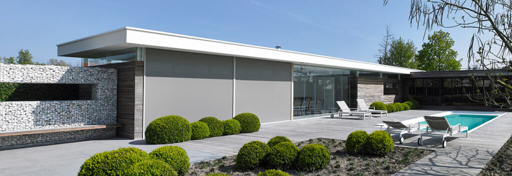 Modern house with large windows and minimalist garden.